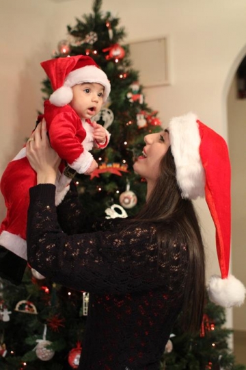 Newborn baby with Santa Hat, held by his mother