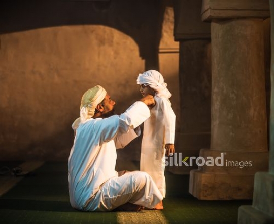 Old man fixing outfit of grandson|-