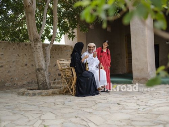 Parents having Arabic coffee under the tree|-