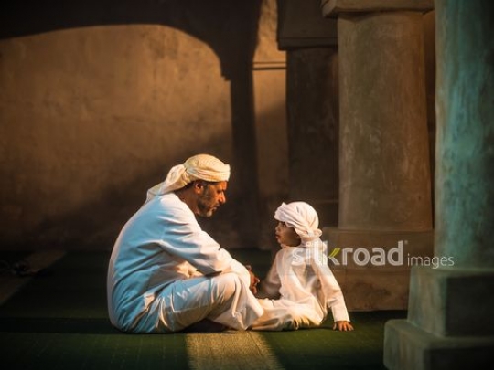 Grandfather teaching boy at the mosque|-