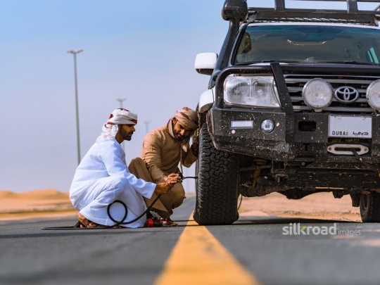 Guys fixing car wheel