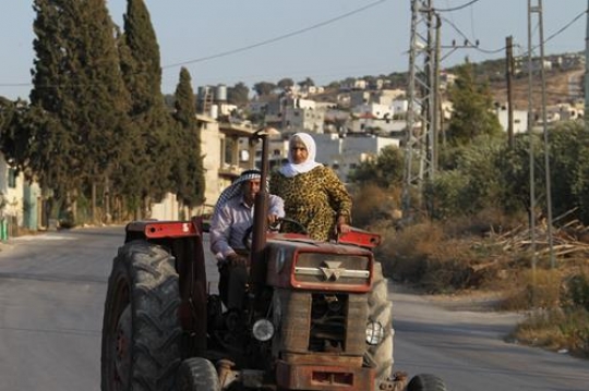 senior couple riding the tractor on the street