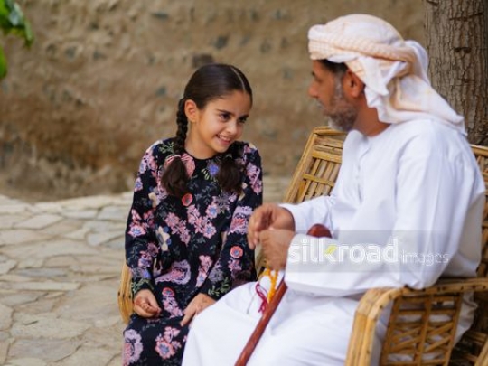 Girl sitting with her grandfather|-