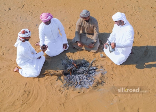 Top view of friends gathering around fire