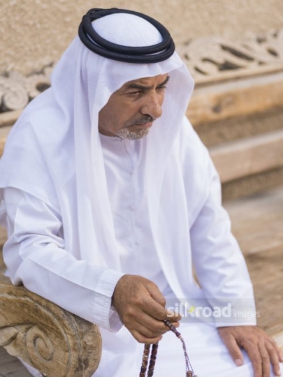 Middle Eastern grandfather sitting with his misbahah|-