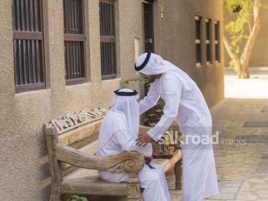 Arab son about to kiss his fathers head|-