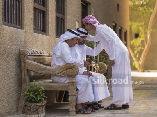Arab son kissing fathers head and grandfather sitting next to him|-