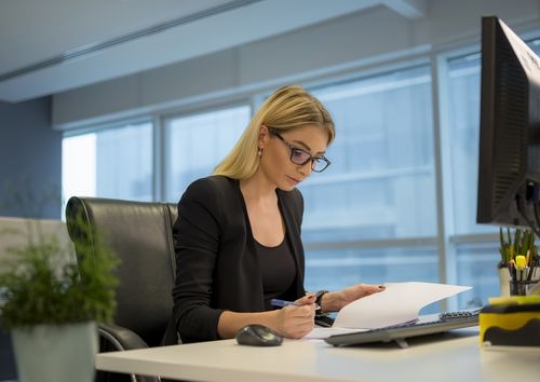 Business woman sitting by her desk doing some work|