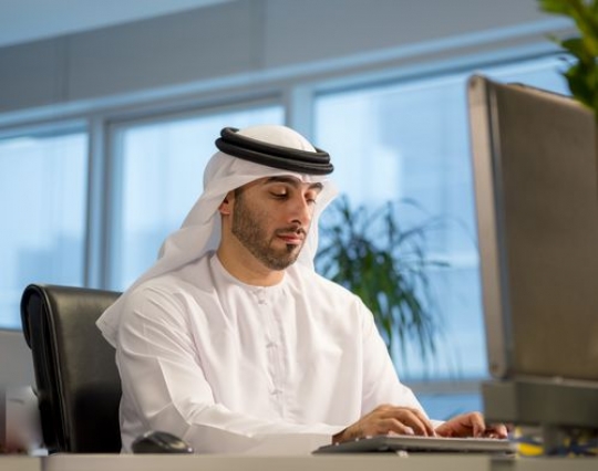 Businessman sitting by his desk typing on the keyboard|
