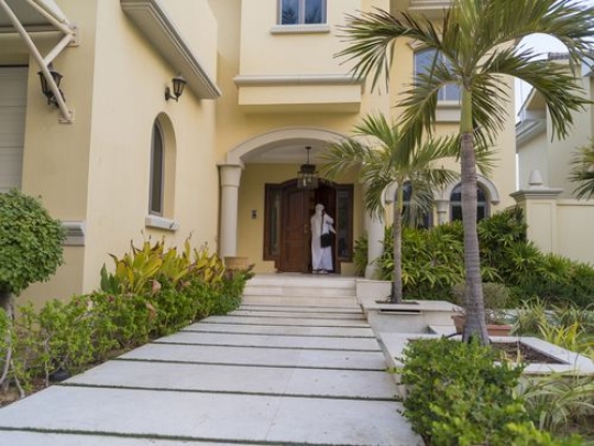Arab man entering his house|-