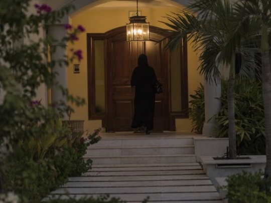 Arab woman entering her home|-