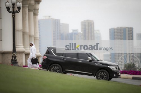 Middle Eastern Businessman dressed in the traditional attire walking|
