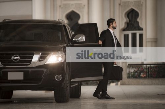 Middle Eastern Businessman closing the door of the car|