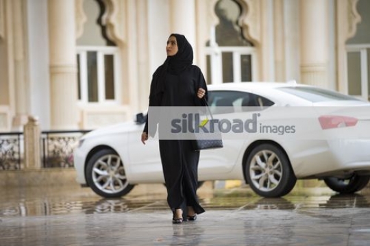 Arab Businesswoman dressed in the traditional UAE attire walking|