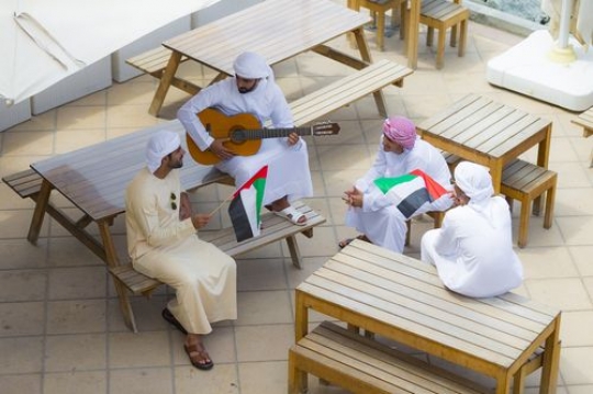 A group of men dressed in the traditional UAE attire celebrating National Day |