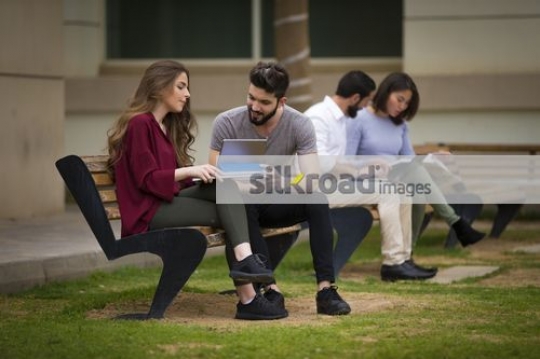 University students sitting together on the bench|
