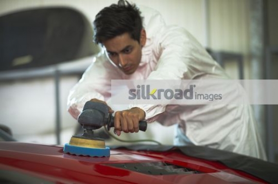 Engineer waxing the red car|