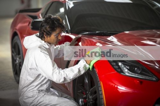Engineer cleaning the red car|
