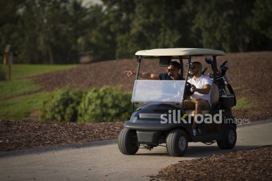 Young Arab men driving around the Resort with the Golf Cart|-