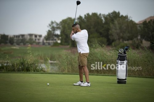 Young Middle Eastern man playing golf|-