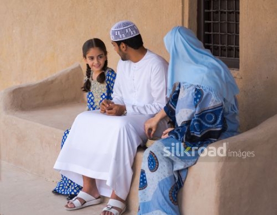 Parents talking with daughter outside|-