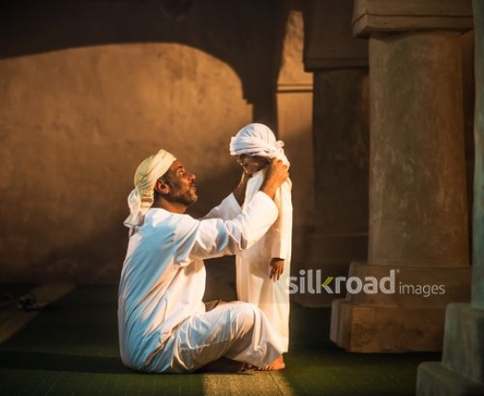 Old man fixing boy's headdress|-