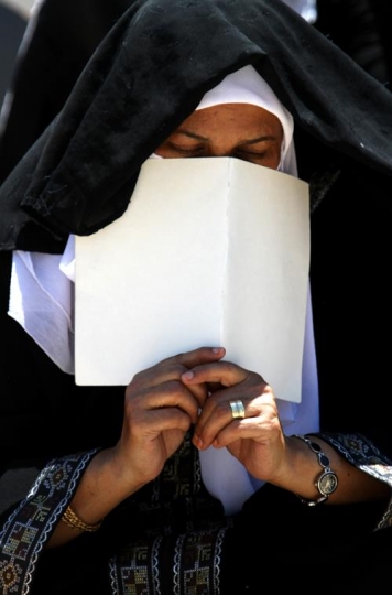 muslim woman putting sheet on 