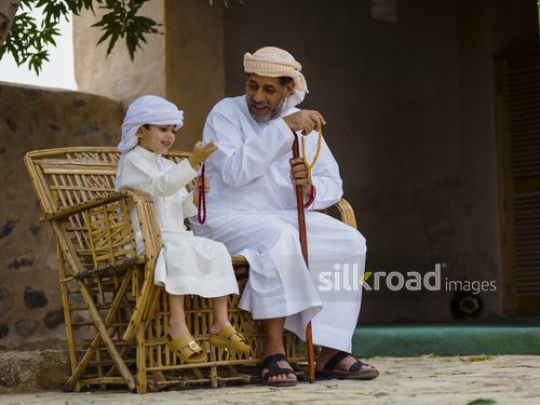 Boy with grandfather holding beads|-