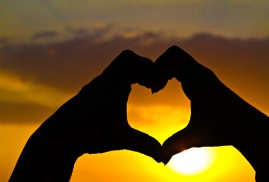 hands making heart with sunset