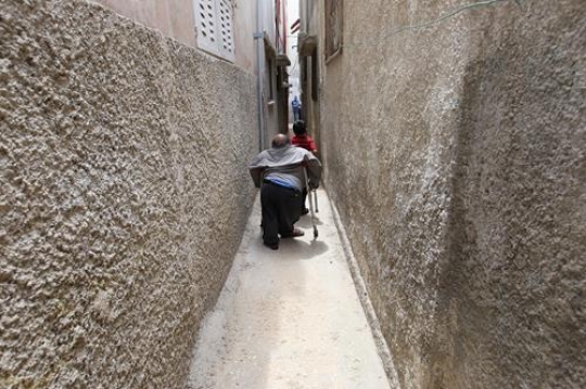disabled man with a little boy walking in alley