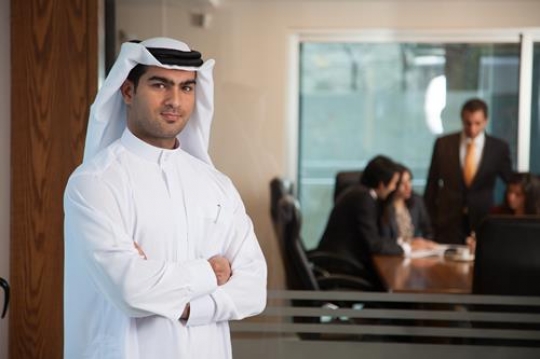 happy young businessman with crossed arms