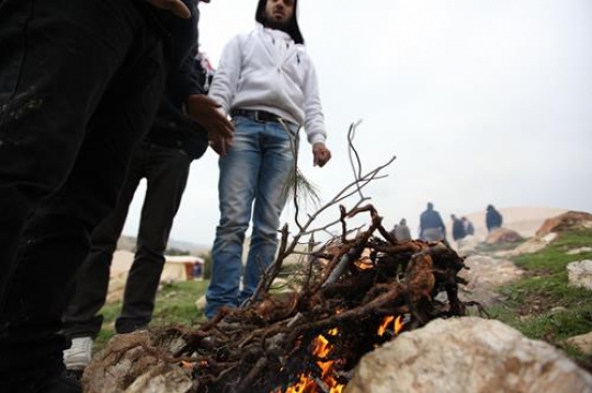 Men Standing Around Campfire