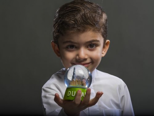 Little boy holding snowball in his hand|