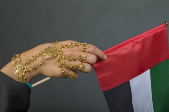 Close up of a woman carrying the UAE flag with her traditional jewellery