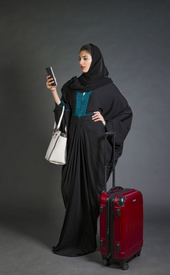Middle Eastern Business woman standing using her phone|-