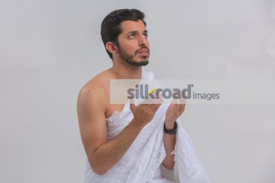 Young Middle Eastern man praying|